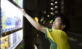 自動販売機で飲み物を買うげんちゃんの横顔