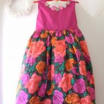 鮮やかなピンクと花柄の生地の子ども用ドレス