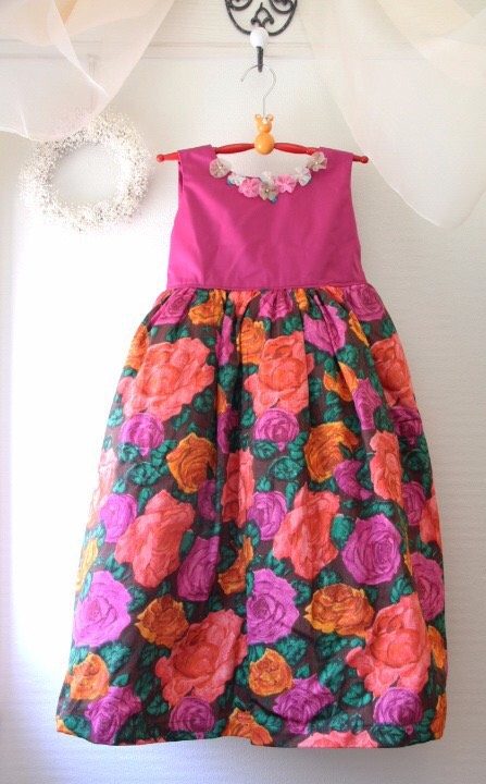 鮮やかなピンクと花柄の生地の子ども用ドレス