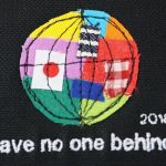 ミシンで刺繍された地球。日本のほかさまざまな国旗、色が組み合わさっている。