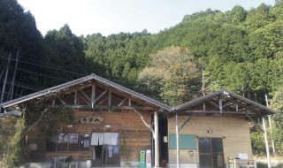 ２棟並んだ木造の建物。すぐうしろには山がせまっている