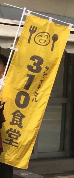 黄色の布に310食堂と書かれた旗。